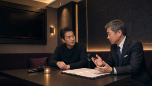カラオケ個室で事業譲渡について相談する店舗オーナーとM&Aアドバイザー